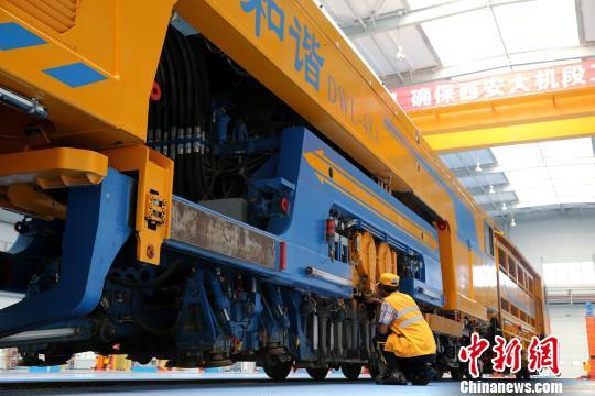 圖為工人正在清理大型養(yǎng)路機(jī)械?！堖h(yuǎn) 攝